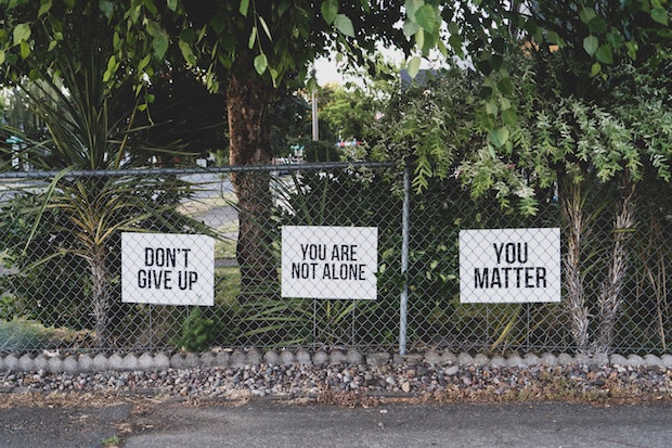 inspirational signs on a metal fence