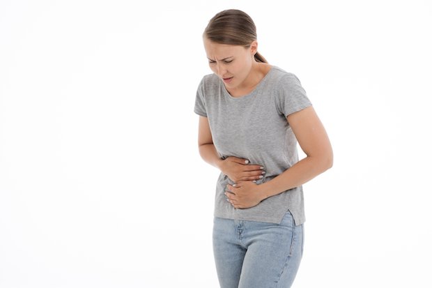 A woman holding her stomach in pain