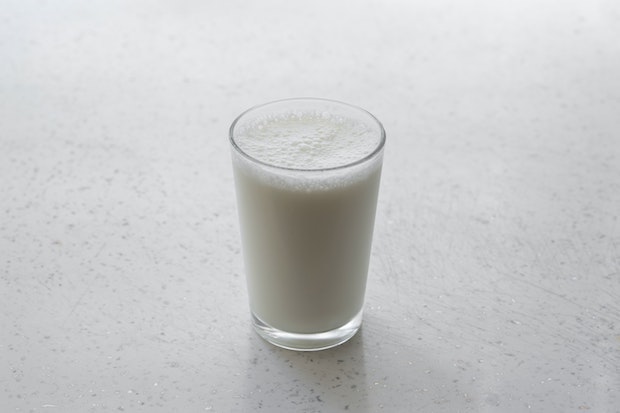 a glass of milk on a white table